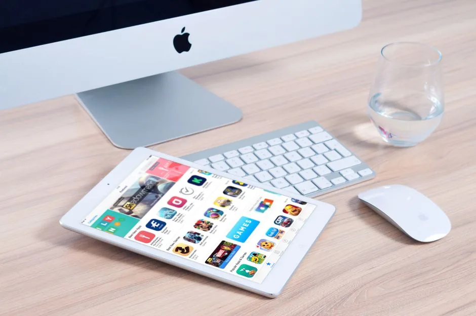 Sleek home office setup featuring an iMac and iPad showcasing apps.
